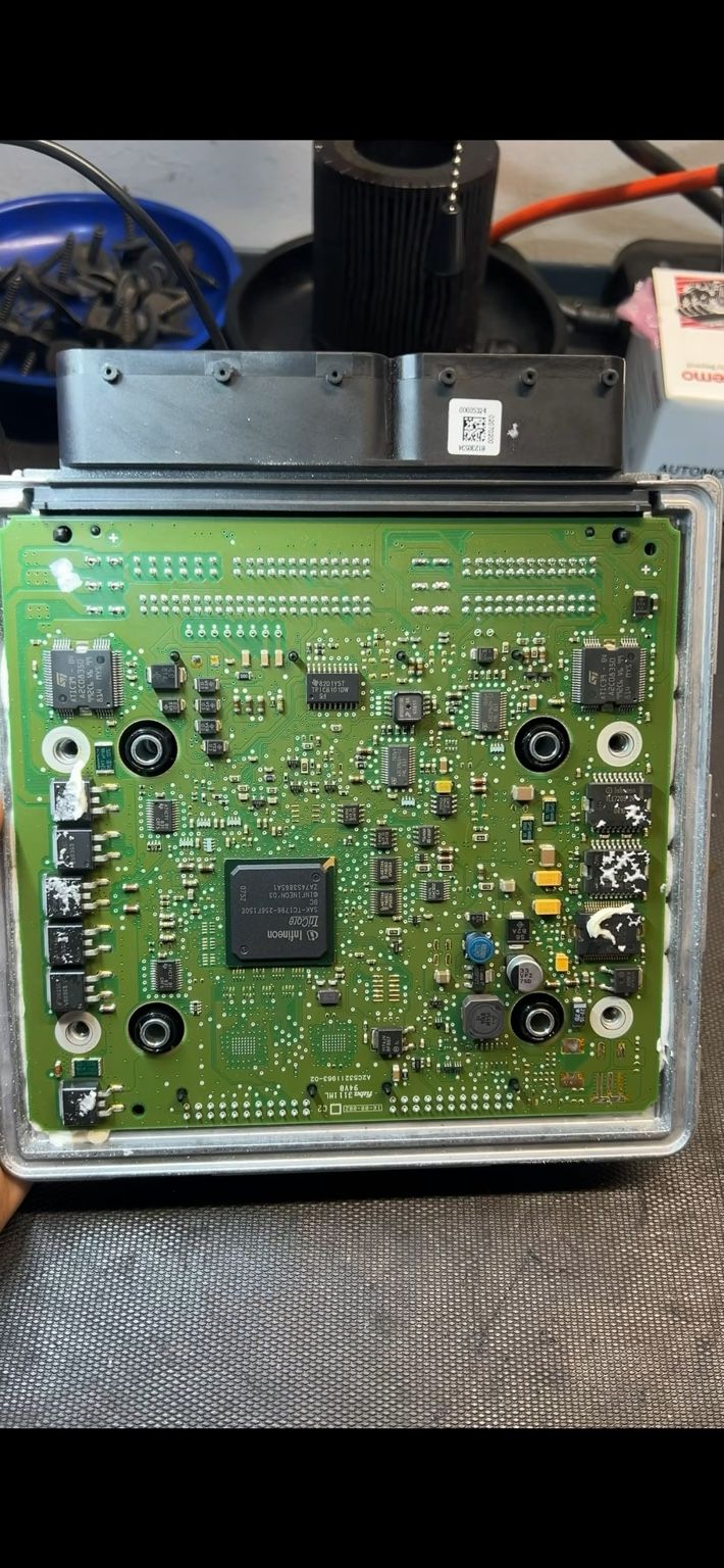 Engine control unit opened on the bench, showing its circuit board, main Infineon processor and connector housing